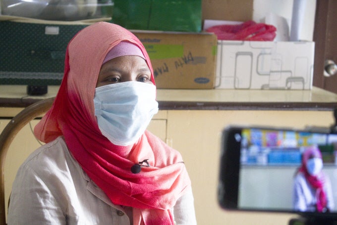 Raisa keenly listens to the health advice of the health worker at the rural health unit. 