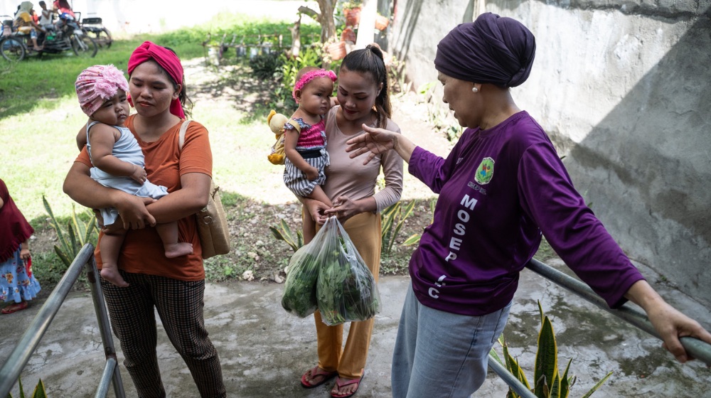 Arrival of the community participants and their children for the Positive Deviance/Hearth (PDH) programme of the Women-Friendly Space in Datu Odin Sinsuat. Photo: UNFPA Philippines / Ferdinandh Cabrera