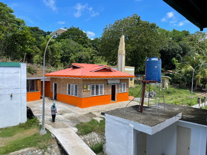 A photo of one of UNFPA Philippines' women-friendly spaces and a woman standing beside it