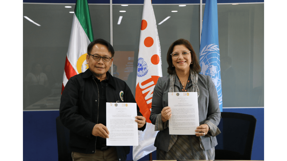 UNFPA Philippines Country Representative and BARMM Minister of Health pose for a photo holding the signed MOU.