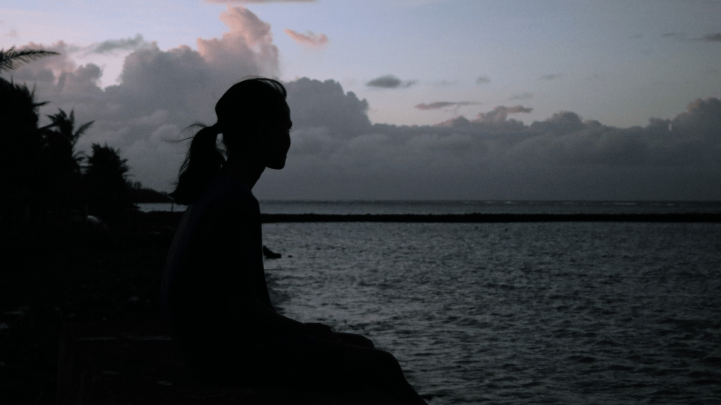 A girl by the coast looking at the horizon