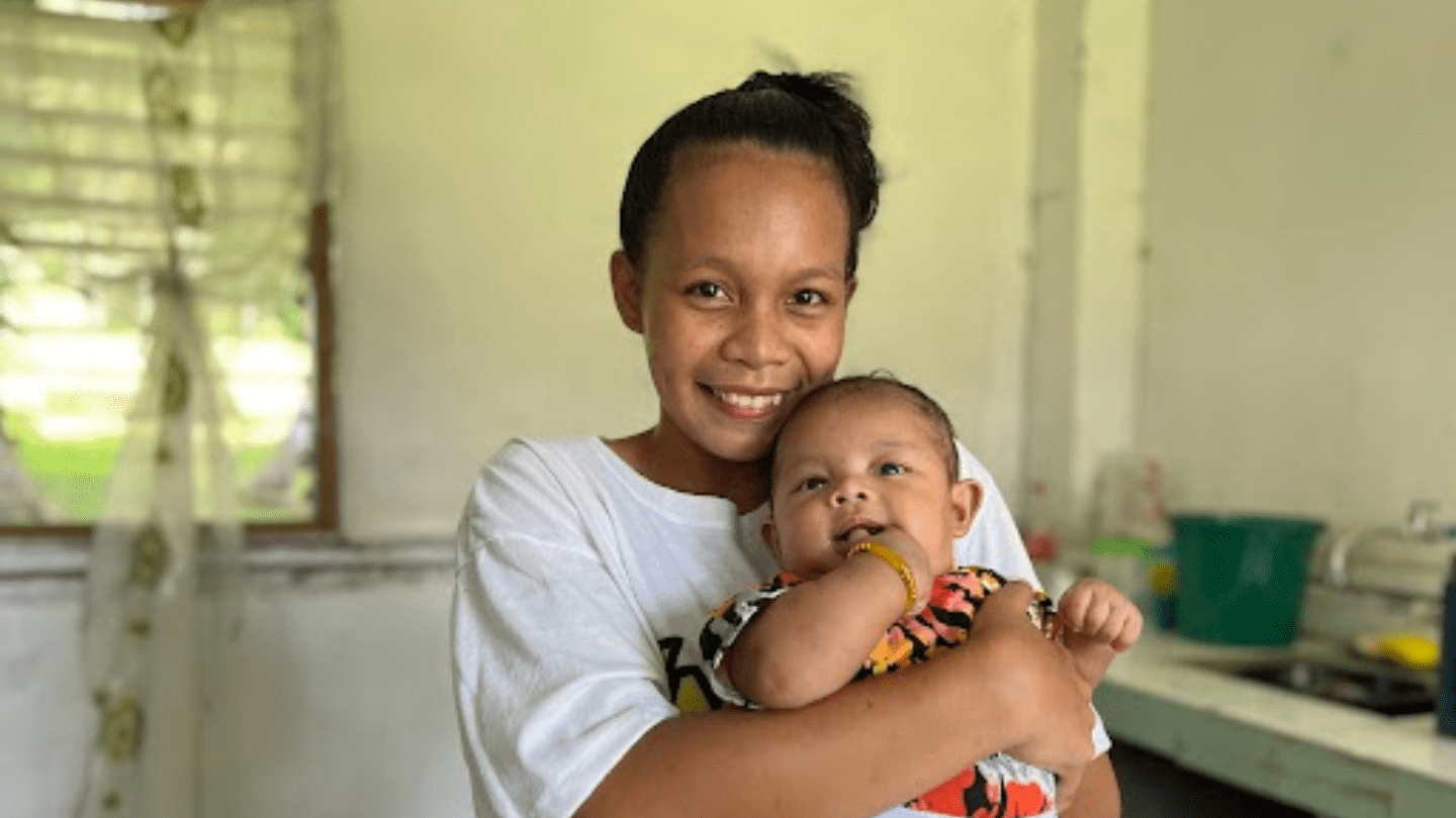 Young mother pose for a photo with her baby. 