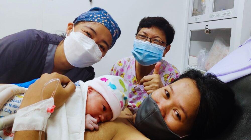  Mother cradles her newborn after a successful delivery with the support from midwives of Women's Health on Wheels