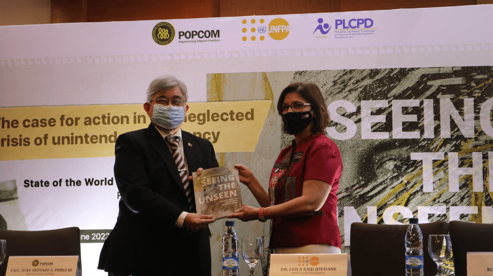 Dr. Leila Joudane, Country Representative of UNFPA Philippines, hands over the 2022 State of World Population Report to Mr. Anto