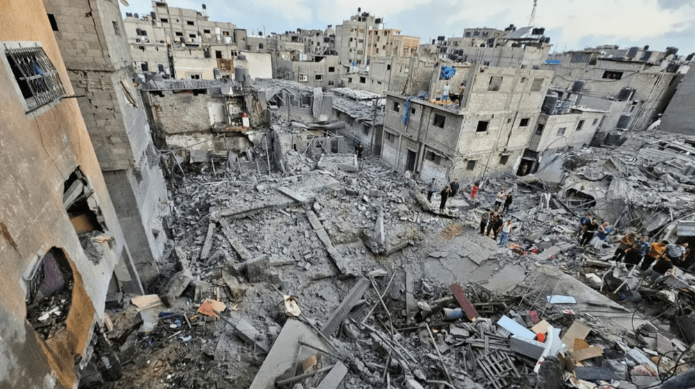 Palestinians gather at site of Israeli strikes on houses in the northern Gaza Strip on 19 October. © REUTERS/Anas al-Shareef